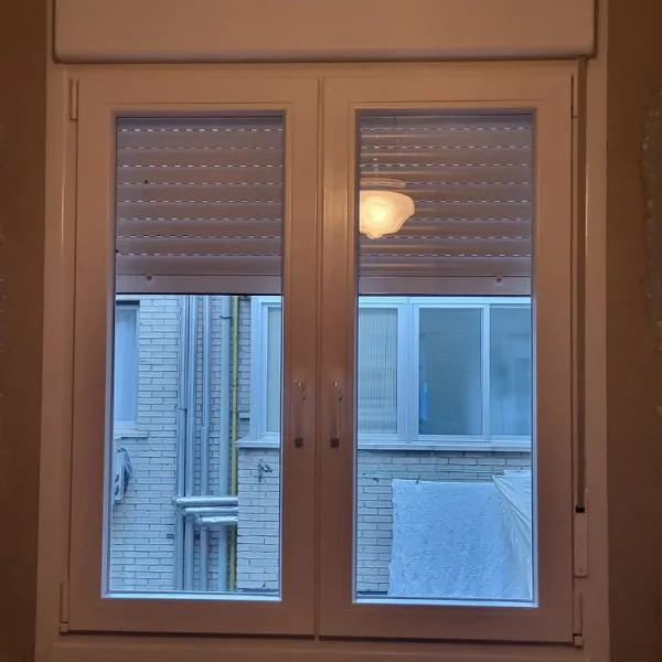 Ventana abatible de PVC de doble hoja con marco blanco